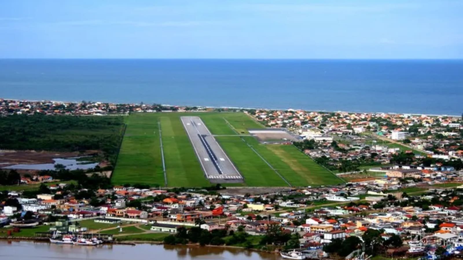 Vista aérea da pista do Aeroporto Internacional de Navegantes, o mais próximo do Beto Carrero World, com o mar ao fundo